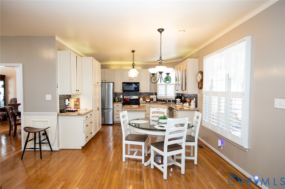110 Jesse's Way Farmville, VA 23901 - Photo 12 of 56 a kitchen with stainless steel appliances kitchen island granite countertop a table chairs and a wooden floor