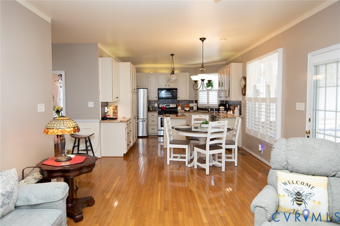 110 Jesse's Way Farmville, VA 23901 - Photo 22 of 56 a kitchen with stainless steel appliances kitchen island granite countertop a stove a refrigerator a dining table and chairs with wooden floor