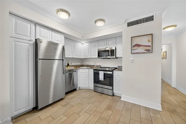 a kitchen with cabinets and stainless steel appliances
