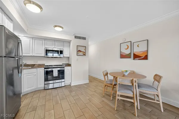 a kitchen with stainless steel appliances a stove a sink cabinets and a dining table