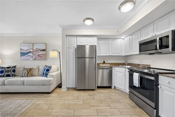 a kitchen with stainless steel appliances granite countertop a refrigerator a stove a microwave a sink and dishwasher