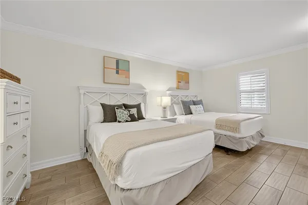 a bedroom with two beds and a window