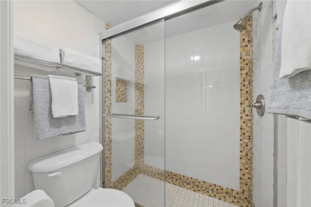 a bathroom with a granite countertop shower a toilet and a sink