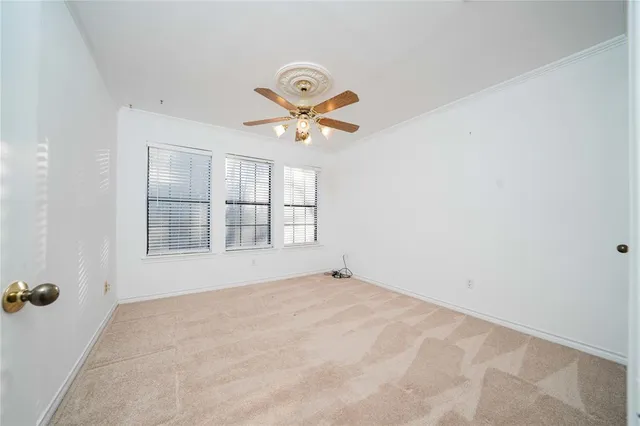 an empty room with windows and ceiling fan