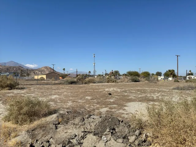 a view of a dry yard with wooden fence