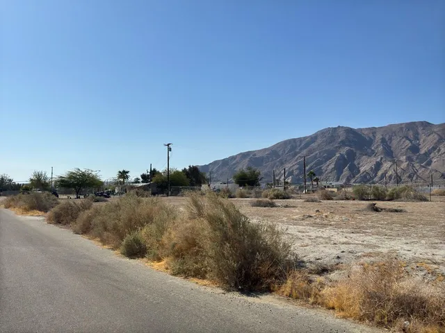a view of a dry yard with wooden fence