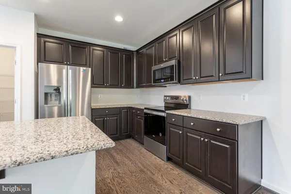 a kitchen with granite countertop wooden cabinets and stainless steel appliances