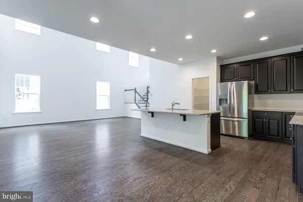 a large white kitchen with kitchen island a island a sink a stove a refrigerator and cabinets