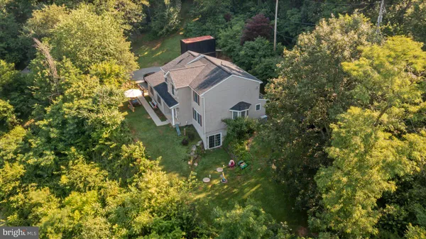 an aerial view of a house with swimming pool and garden space