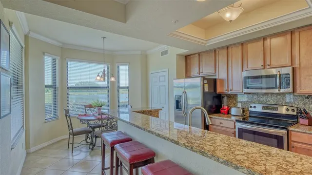 a kitchen with sink a refrigerator and chairs