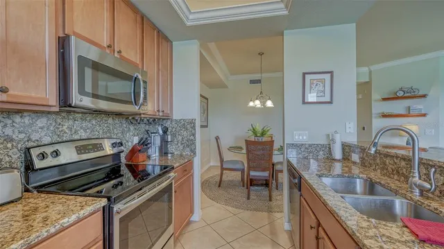 a kitchen with granite countertop a stove a sink and a microwave