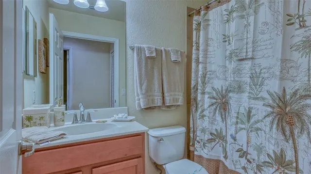 a bathroom with a granite countertop sink toilet a mirror and shower