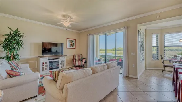 a living room with furniture a flat screen tv and a large window