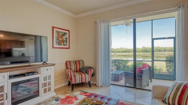 a living room with furniture a flat screen tv and a floor to ceiling window