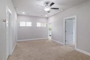 an empty room with closet and a ceiling fan