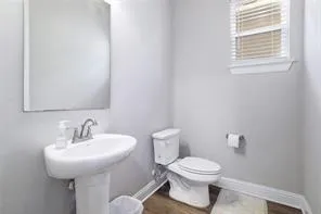 a bathroom with a granite countertop sink a toilet a mirror and a tub