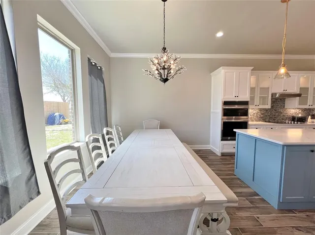 a view of a dining room with furniture a chandelier and wooden floor