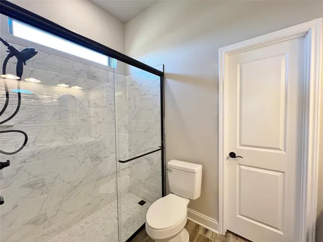 a bathroom with a toilet and a shower