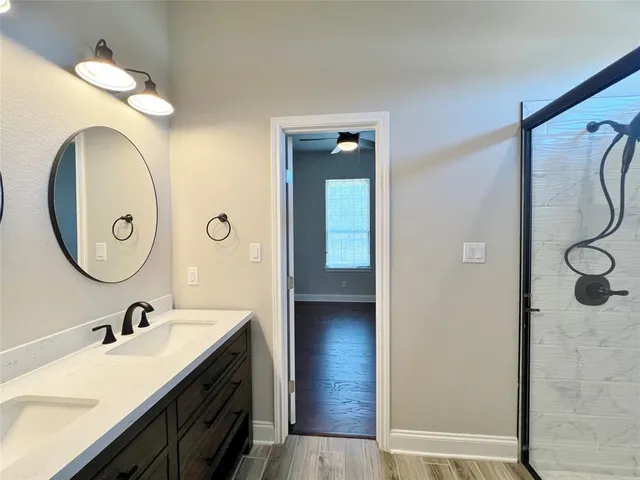 a bathroom with a double vanity sink mirror and shower