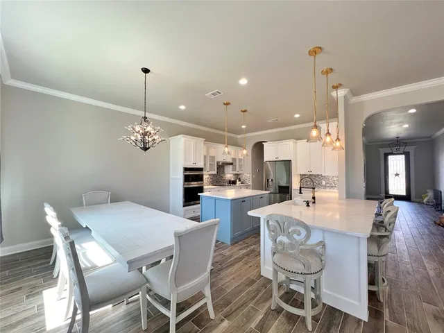 a view of a dining room and livingroom with furniture wooden floor a chandelier