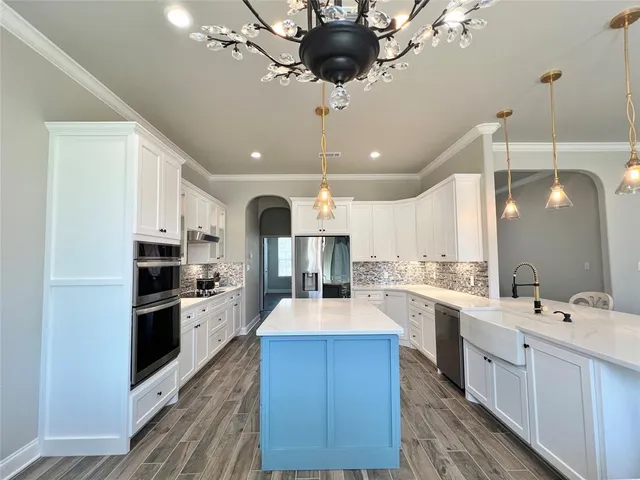 a large kitchen with a large counter top appliances and cabinets