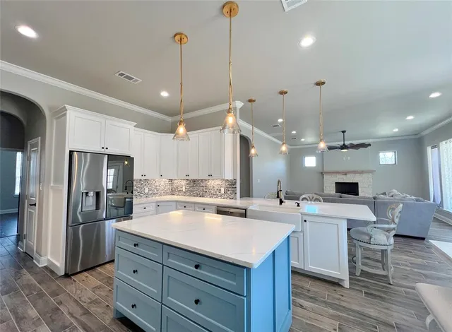 a kitchen with a stove a refrigerator and chairs