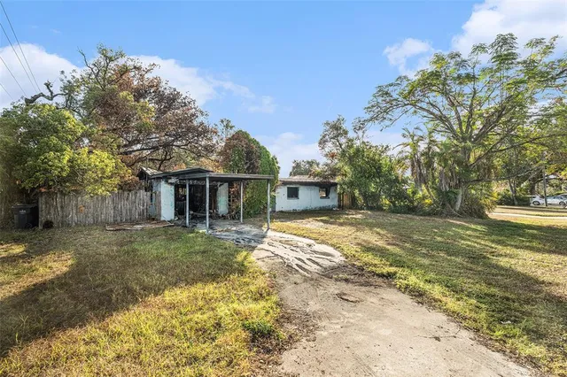 a view of a house with backyard and tree