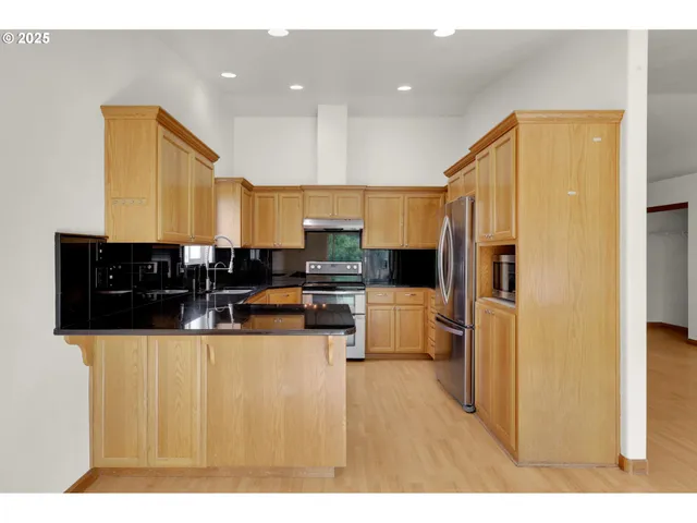 a kitchen with stainless steel appliances a refrigerator and a stove