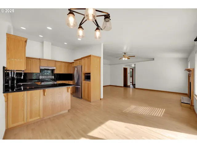 a kitchen with stainless steel appliances kitchen island a refrigerator sink and cabinets