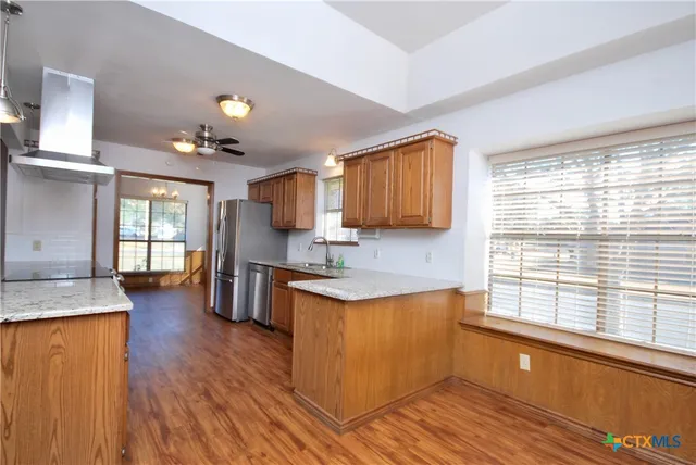 a living room with a fireplace and a ceiling fan