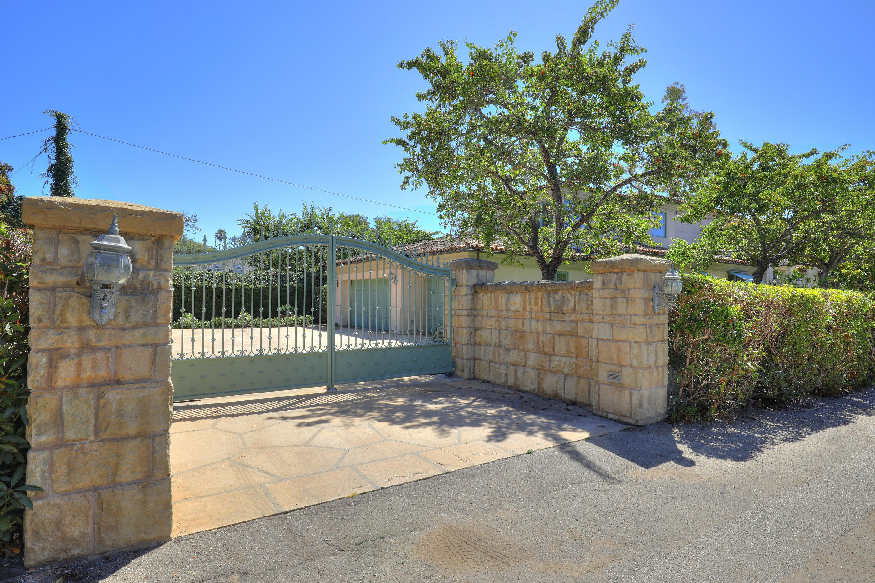 1138 Hill Road Montecito, CA 93108 - Photo 13 of 15 a view of a brick house with a large tree and wooden fence