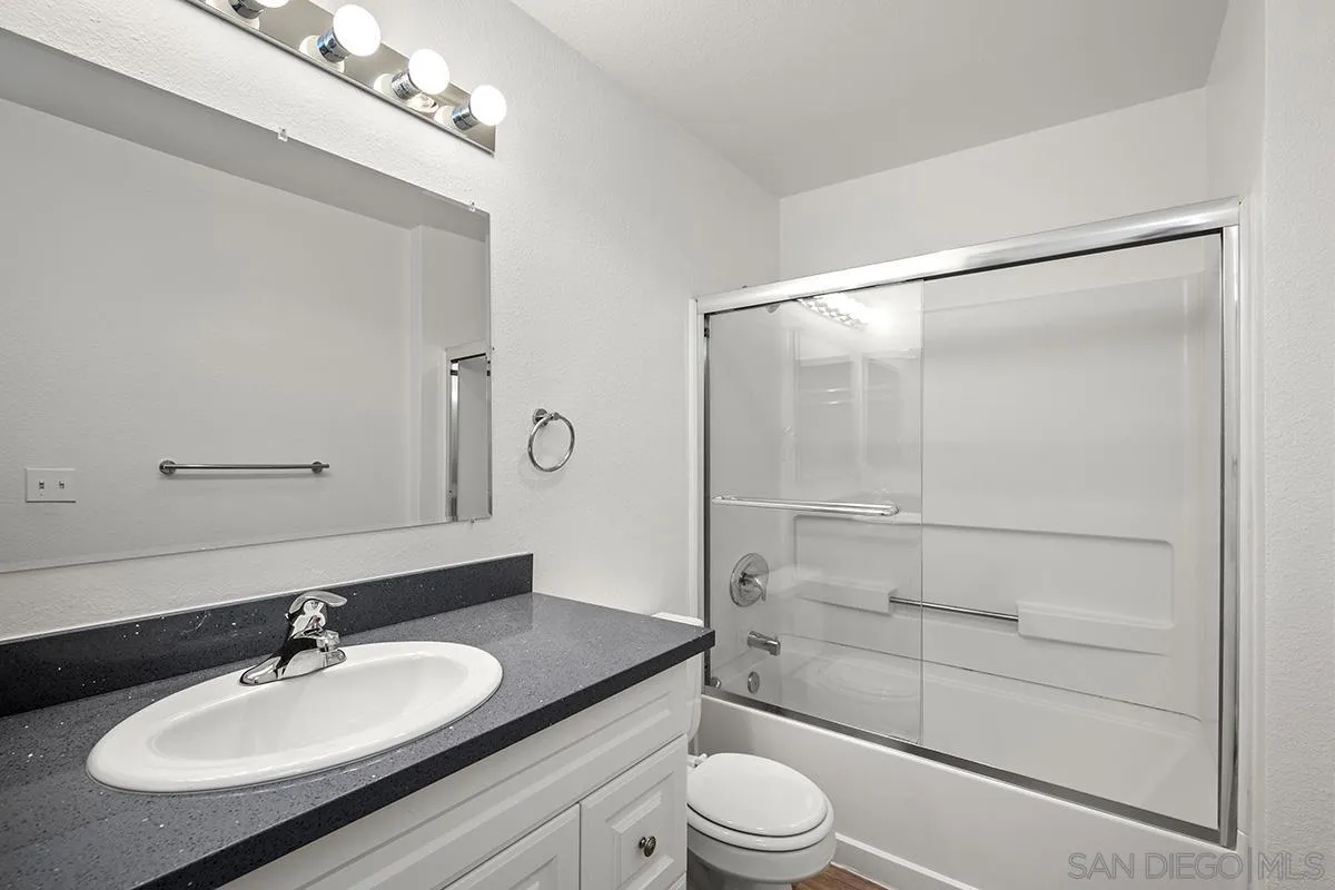6006 Rancho Mission Road San Diego, CA 92108 - Photo 20 of 32 a bathroom with a sink toilet a mirror and shower
