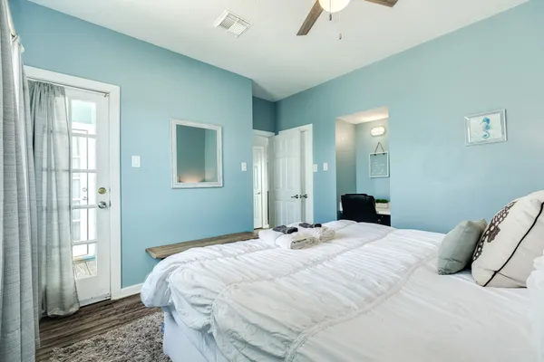 a bedroom with a bed a ceiling fan and a dresser