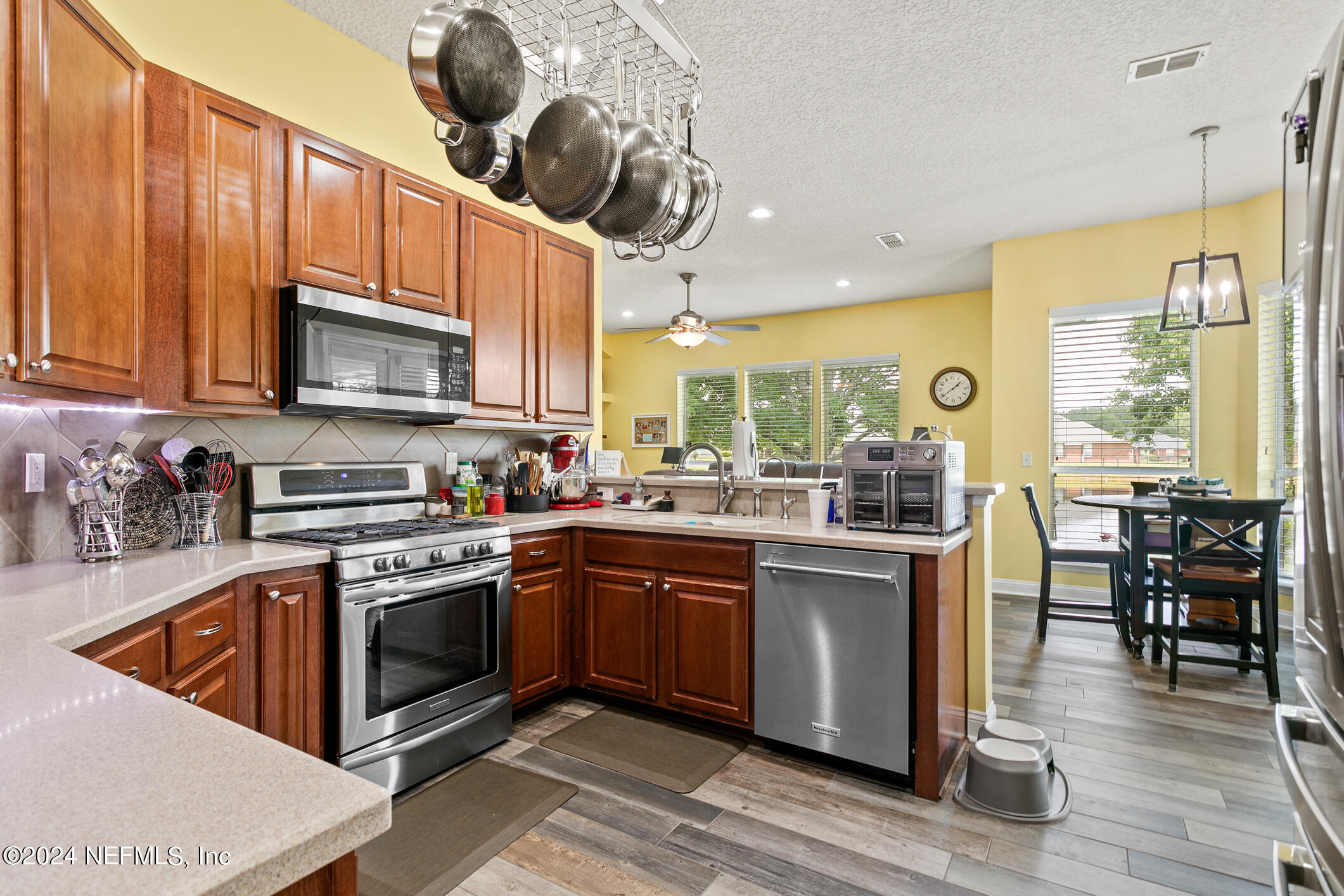 1658 Lockend Road Jacksonville, FL 32221 - Photo 17 of 54 a kitchen with stainless steel appliances granite countertop wooden cabinets a stove top oven a sink and dishwasher a dining table with wooden floor