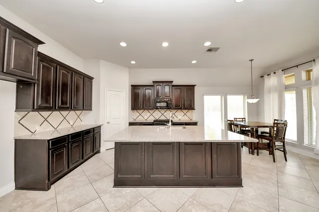 a large white kitchen with a large window and kitchen view
