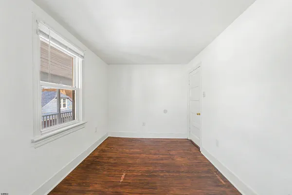 a view of a room with wooden floor and windows
