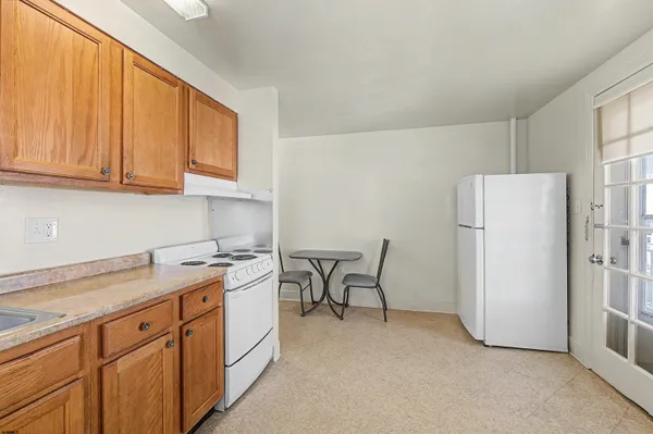 a kitchen with a refrigerator a stove a sink and cabinets