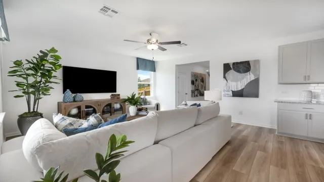 a living room with furniture kitchen view and a chandelier