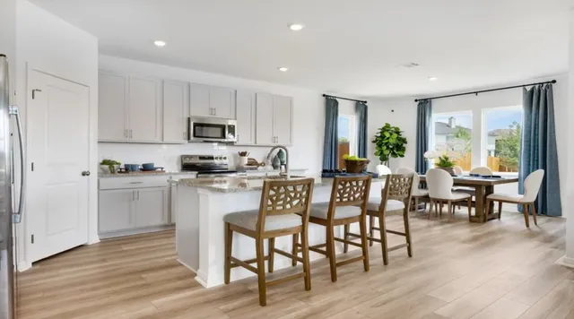 a kitchen with a dining table chairs and refrigerator