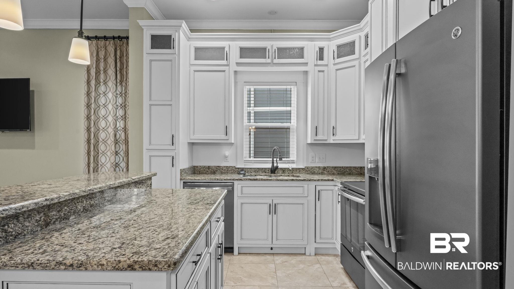 12361 Reunion Place Foley, AL 36535 - Photo 11 of 43 Kitchen featuring appliances with stainless steel finishes, glass insert cabinets, white cabinetry, and crown molding