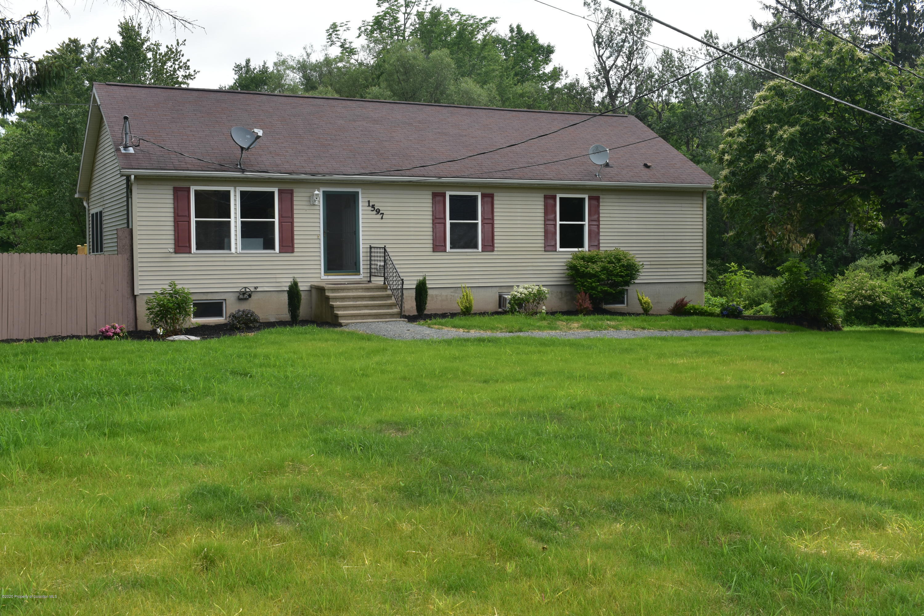 a front view of a house with a garden and yard