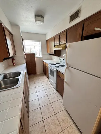 a kitchen with stainless steel appliances a refrigerator sink and stove