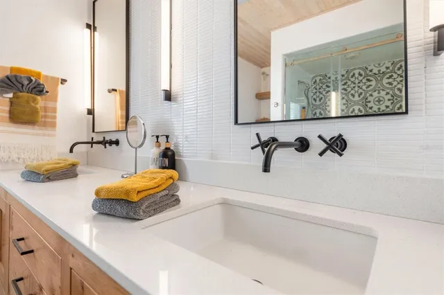 a bathroom with a sink a toilet and shower