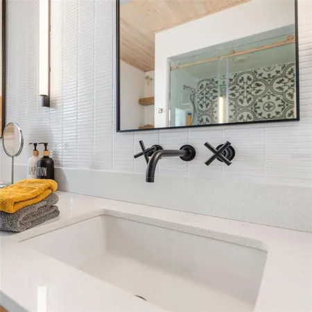 a bathroom with a toilet sink a mirror and shower