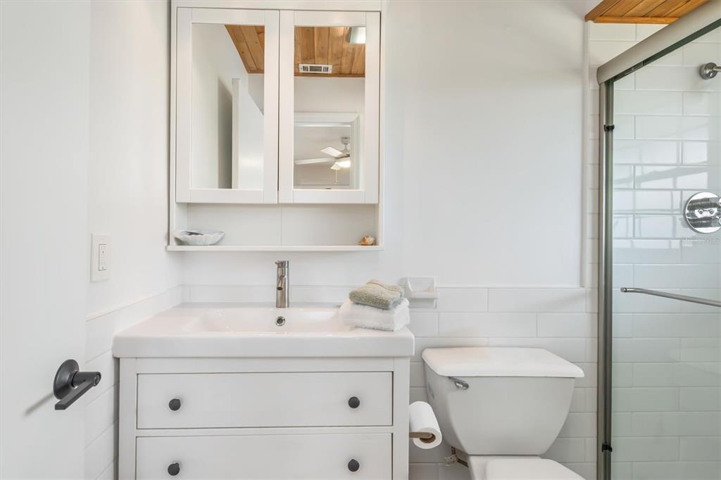 9498 Alborado Road Boca Grande, FL 33921 - Photo 37 of 81 a bathroom with a toilet sink a mirror and shower