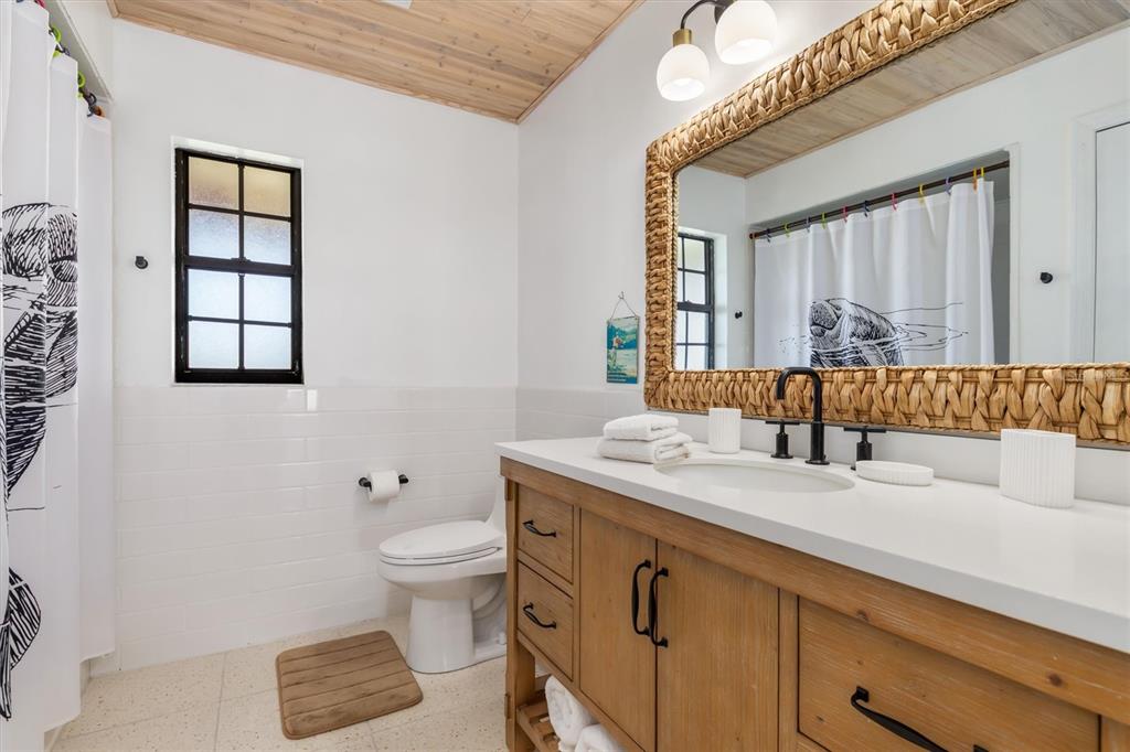9498 Alborado Road Boca Grande, FL 33921 - Photo 39 of 81 a spacious bathroom with a granite countertop double vanity sink a mirror and a toilet