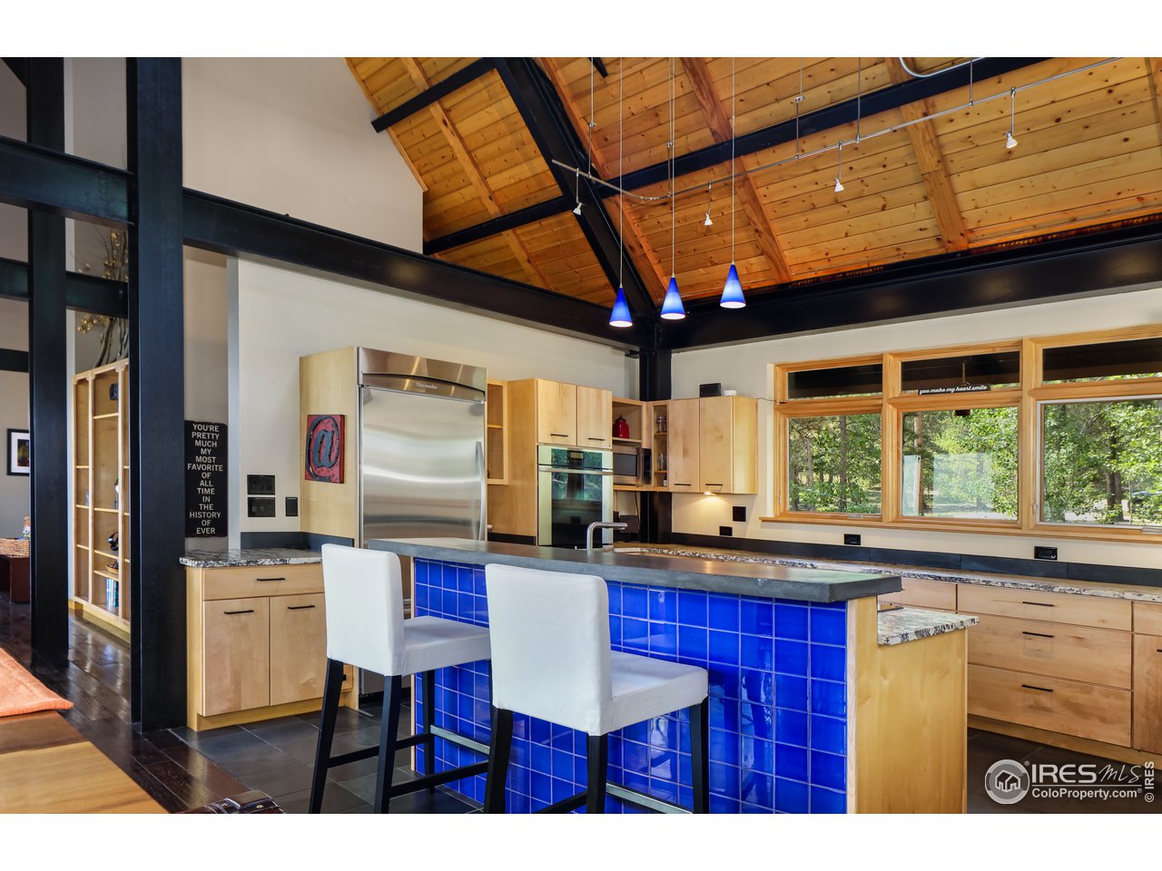 116 Ramona Road Golden, CO 80403 - Photo 20 of 40 a kitchen with stainless steel appliances kitchen island granite countertop a table chairs in it and wooden floors