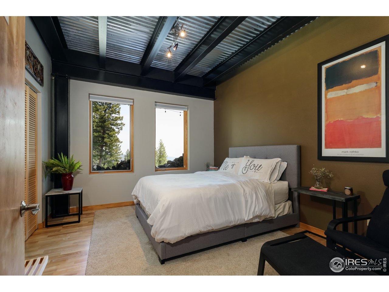 116 Ramona Road Golden, CO 80403 - Photo 35 of 40 a bedroom with a bed and wooden floor