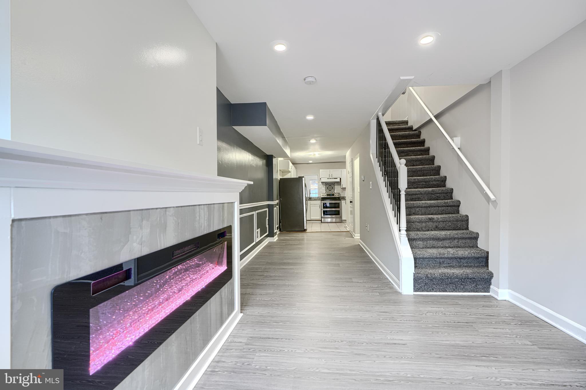 1127 Sargeant Street Baltimore, MD 21223 - Photo 6 of 34 a hallway with wooden floor and stairs