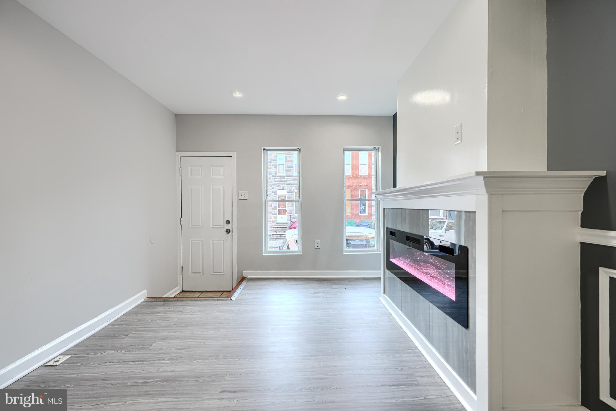 1127 Sargeant Street Baltimore, MD 21223 - Photo 8 of 34 a view of a livingroom with wooden floor and a fireplace